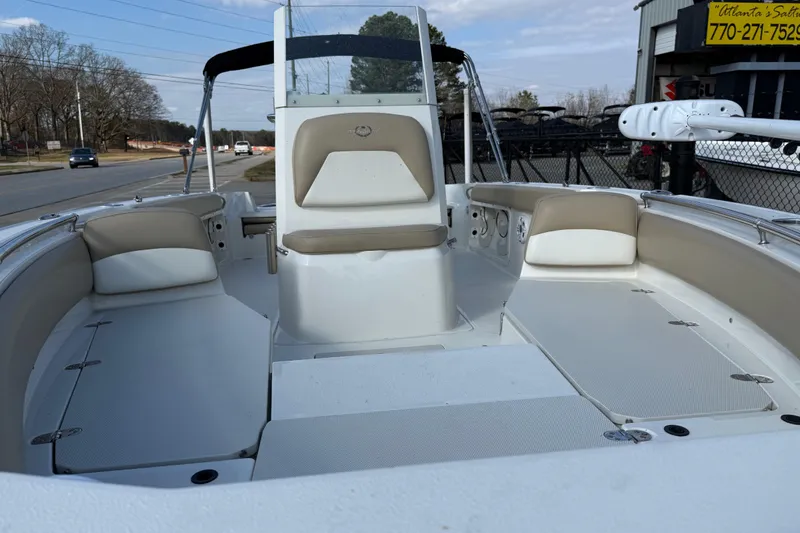 Slide: The Image of 2019 Stingray 236 CC boat interior with beige seating and open deck layout. - 39
