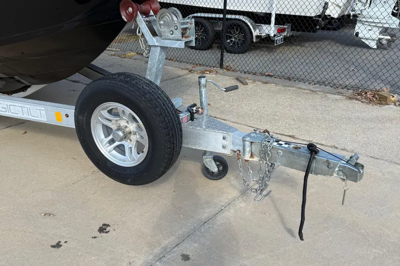 Slide: The Image of Trailer hitch and wheel of a 2019 Stingray 236 CC boat on pavement. - 41
