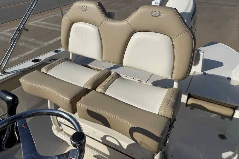 Slide: The Image of 2019 Stingray 236 CC boat with beige and white seating, steering wheel visible. - 6