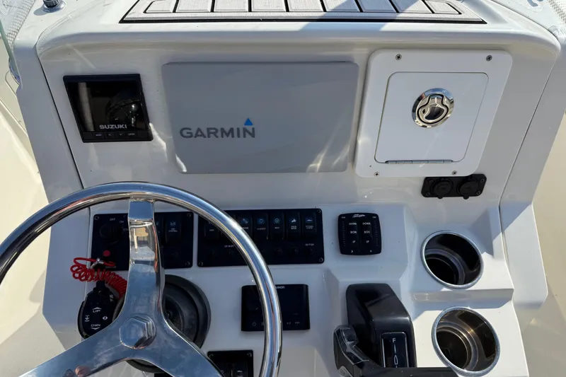 Slide: The Image of 2019 Stingray 236 CC boat dashboard with Garmin display and Suzuki controls. - 8