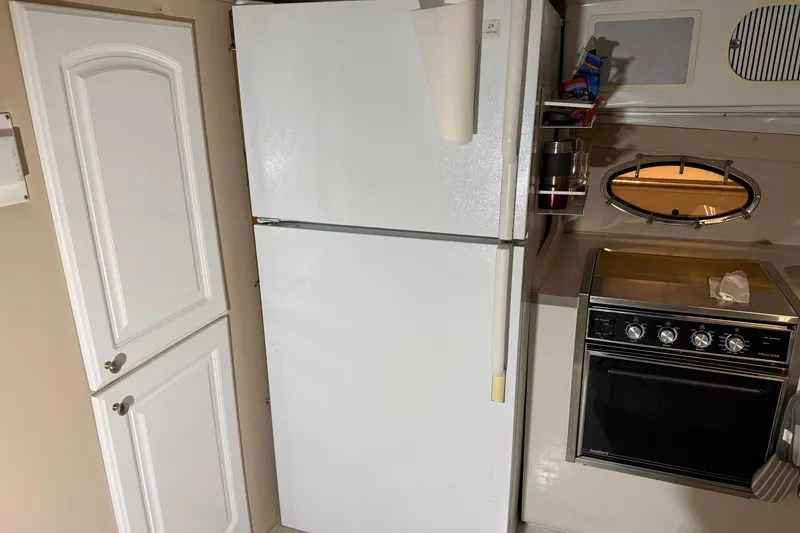 Slide: The Image of Kitchen area of 1988 Trojan 13 Meter Express 430 with fridge and stove. - 12