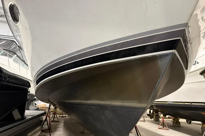 Slide: The Image of 1988 Trojan 13 Meter Express 430 boat in storage, showcasing sleek hull design. - 17