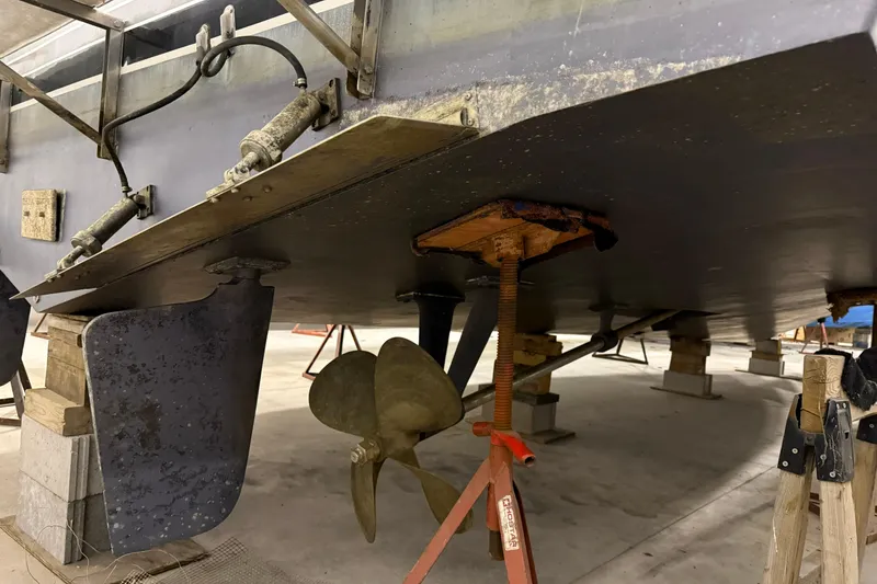 Slide: The Image of 1988 Trojan 13 Meter Express 430 boat underside with propeller and rudder in dry dock. - 21