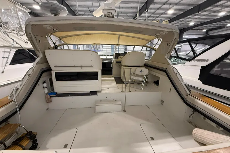 Slide: The Image of 1988 Trojan 13 Meter Express 430 yacht interior with seating and helm in a marina. - 22