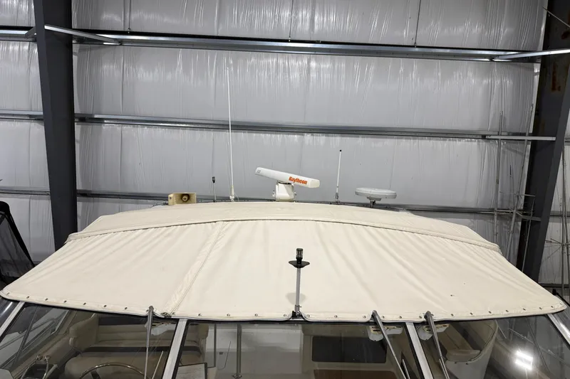 Slide: The Image of 1988 Trojan 13 Meter Express 430 boat with canvas cover in storage facility. - 38