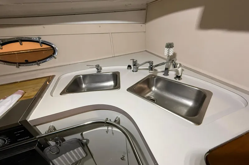 Slide: The Image of 1988 Trojan 13 Meter Express 430 yacht kitchen with dual sinks and porthole window. - 42