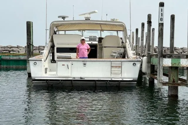 Slide: The Image of 1988 Trojan 13 Meter Express 430 yacht docked with person on deck. - 47