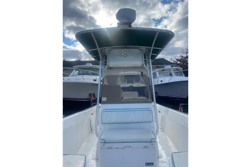 Slide: The Image of 2005 Key Largo 236 Center Console boat with canopy, docked under cloudy sky. - 9
