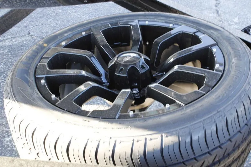 Slide: The Image of Black alloy wheel of a 2026 Phoenix 21 car on asphalt surface. - 19