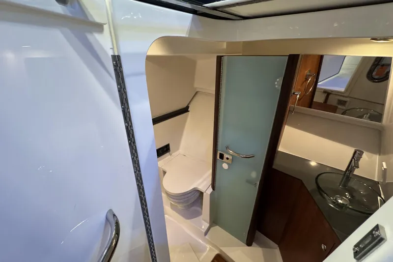 Slide: The Image of Interior of 2026 Pursuit DC 365 Dual Console boat bathroom with modern fixtures. - 21