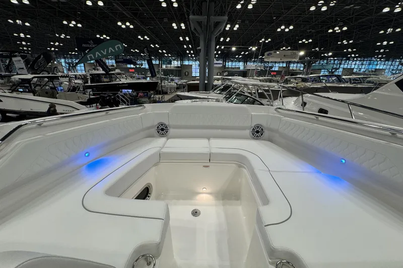Slide: The Image of 2026 Pursuit DC 365 Dual Console boat interior with blue LED lights at a boat show. - 22