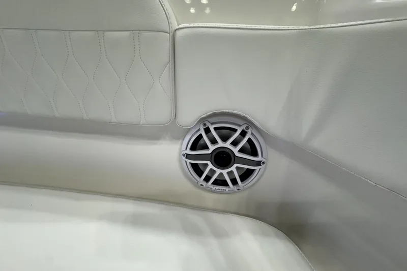 Slide: The Image of 2026 Pursuit DC 365 Dual Console boat interior with white upholstery and built-in speaker. - 24