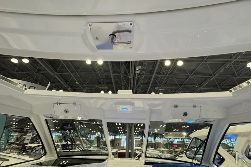 Slide: The Image of 2026 Pursuit DC 365 Dual Console interior at a boat show, showcasing sleek design and lighting. - 26