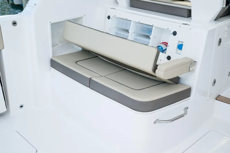 Slide: The Image of 2026 Pursuit DC 365 Dual Console boat interior at a boat show, showcasing seating and helm. - 8