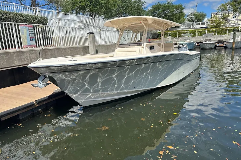 The Image of 2014 Grady-White Canyon 336 boat docked in a marina, reflecting sunlight on water. - 0