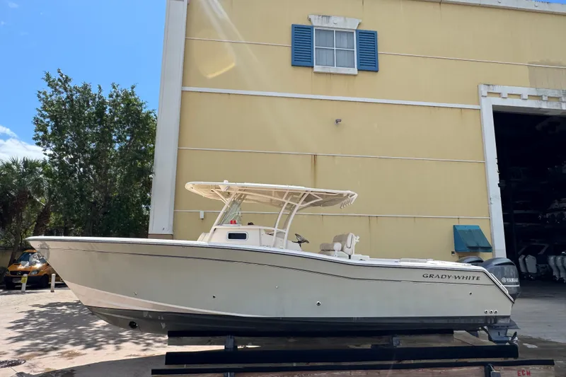 Slide: The Image of 2014 Grady-White Canyon 336 boat displayed outdoors near a yellow building. - 3