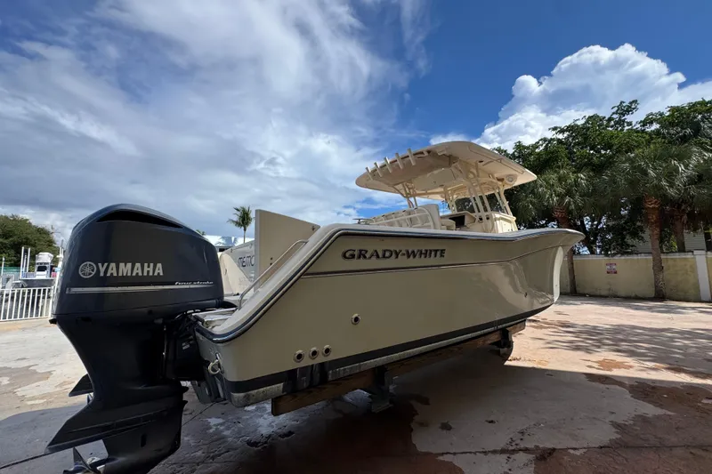 Slide: The Image of 2014 Grady-White Canyon 336 boat with Yamaha engine, parked outdoors under a blue sky. - 6