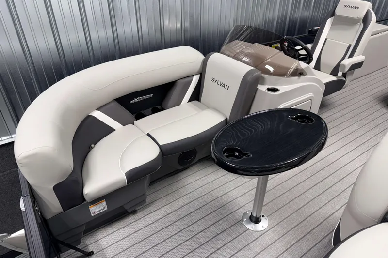 Slide: The Image of Luxurious interior of 2026 Sylvan MIRAGE X1 CLZ DH pontoon boat with plush seating and table. - 2