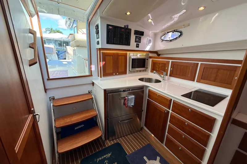 Slide: The Image of 2019 Back Cove Downeast 37 yacht interior with modern kitchen and wooden cabinetry. - 10