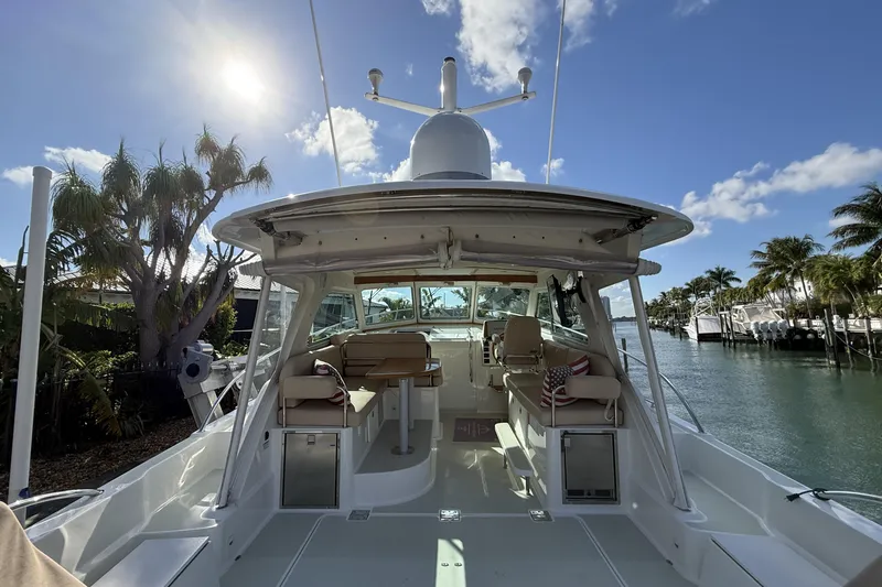 Slide: The Image of 2019 Back Cove Downeast 37 yacht, spacious deck, sunny day, palm trees, waterfront view. - 3