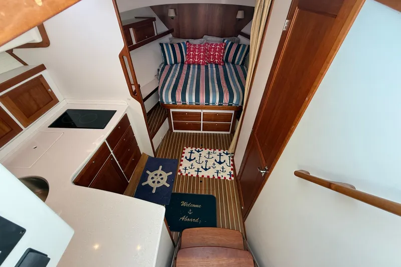 Slide: The Image of 2019 Back Cove Downeast 37 interior with cozy bed, kitchenette, and nautical decor. - 9