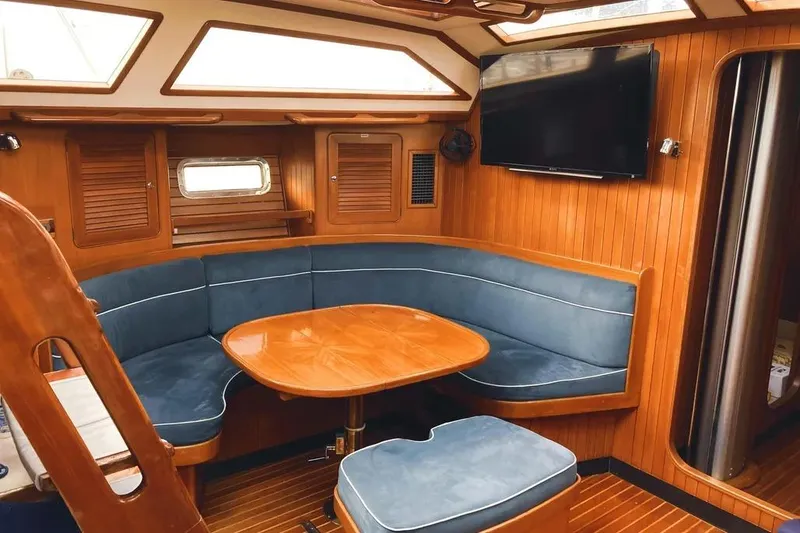 Slide: The Image of Luxurious interior of a 1999 Hylas 54 yacht with wood paneling and blue seating. - 15