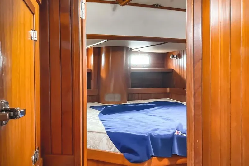 Slide: The Image of Cozy cabin interior of 1999 Hylas 54 yacht with wooden paneling and bed. - 16