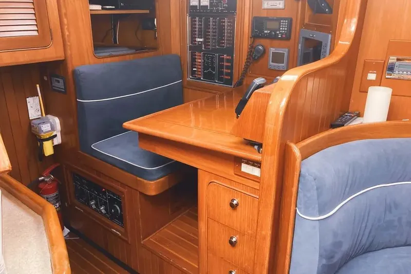 Slide: The Image of Interior of a 1999 Hylas 54 yacht with wooden paneling and navigation equipment. - 18