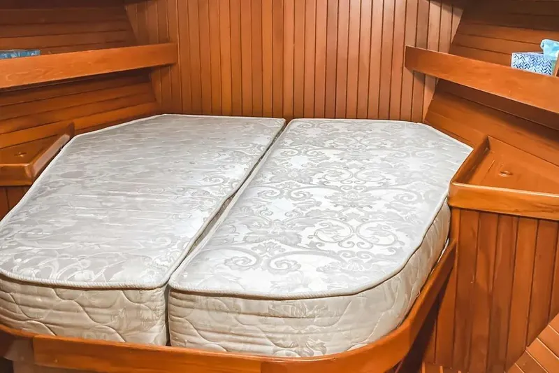 Slide: The Image of Cabin interior of 1999 Hylas 54 yacht with twin mattresses and wooden paneling. - 20