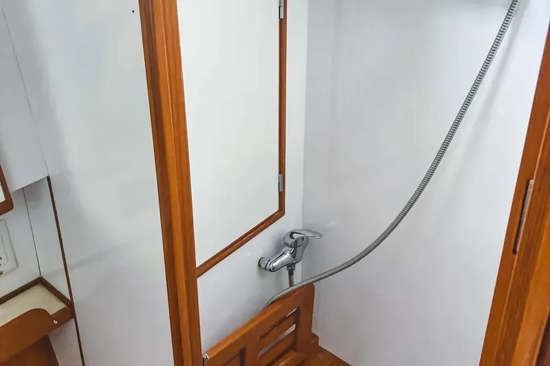 Slide: The Image of Shower area in 1999 Hylas 54 yacht with wooden accents and handheld showerhead. - 22
