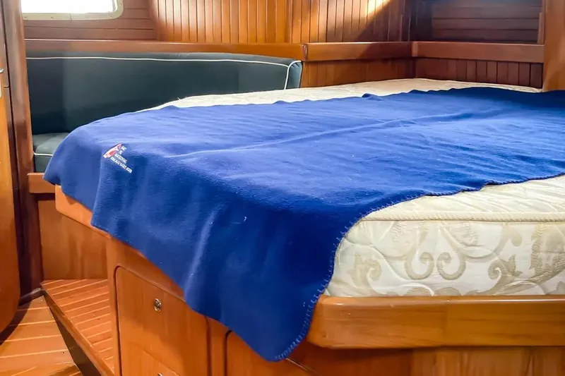 Slide: The Image of Cozy cabin interior of 1999 Hylas 54 yacht with blue blanket on bed. - 24