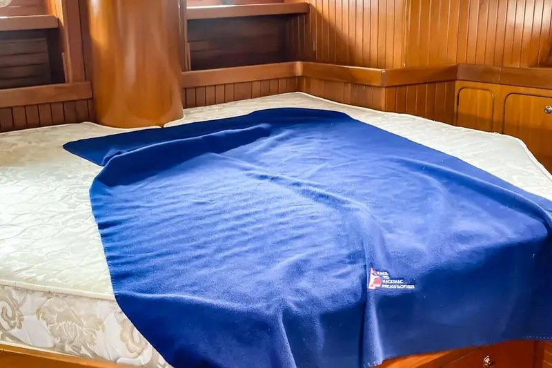 Slide: The Image of Cozy cabin bed with blue blanket on 1999 Hylas 54 yacht. - 26