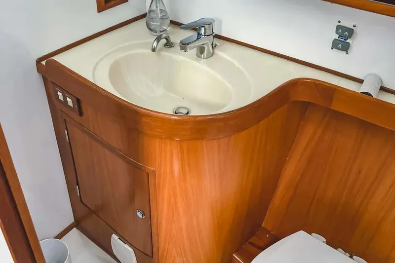 Slide: The Image of Wooden bathroom interior on a 1999 Hylas 54 yacht, featuring a sink and cabinet. - 27