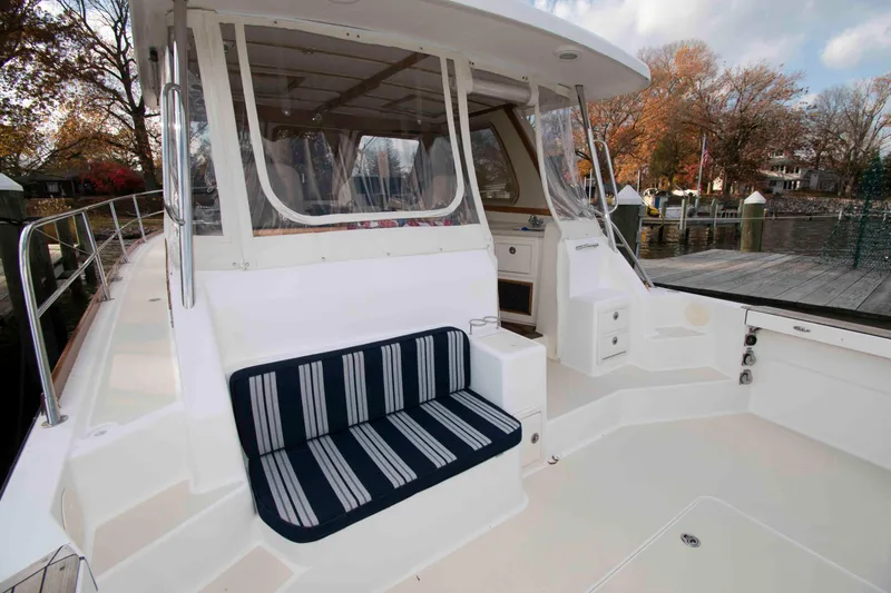 Slide: The Image of 2005 Sabre 38 Hardtop Express docked by a wooden pier in a serene setting. - 10