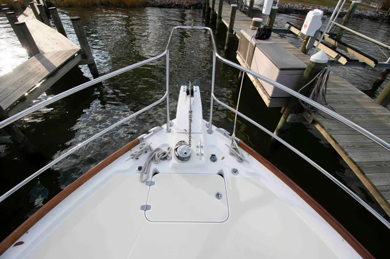 Slide: The Image of 2005 Sabre 38 Hardtop Express docked by a scenic lake under a cloudy sky. - 13