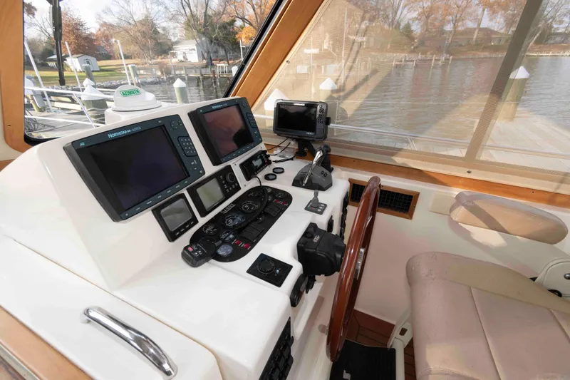 Slide: The Image of 2005 Sabre 38 Hardtop Express docked by a scenic lake under a cloudy sky. - 19