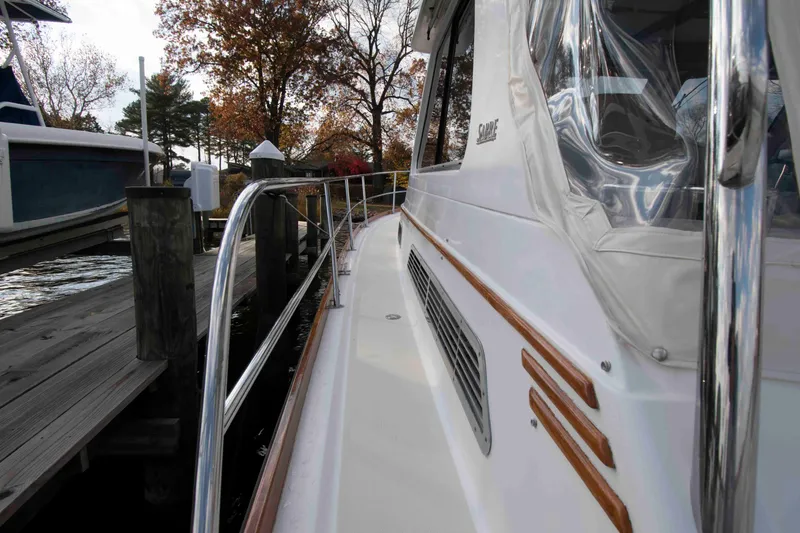 Slide: The Image of 2005 Sabre 38 Hardtop Express docked by a serene lakeside pier. - 6