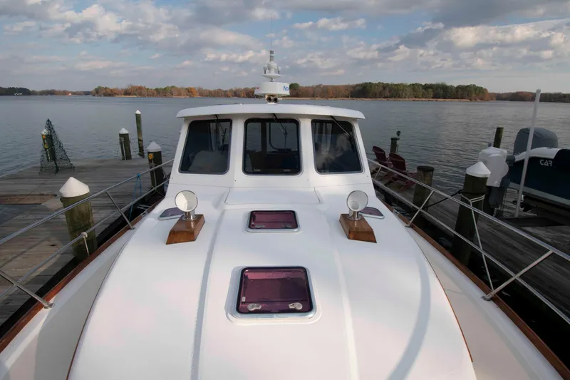 Slide: The Image of 2005 Sabre 38 Hardtop Express docked at a scenic marina with autumn trees. - 8