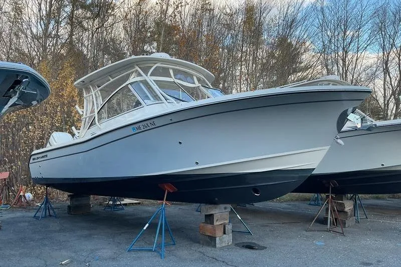 The Image of 2025 Grady-White Freedom 285 boat on stands, outdoors, with trees in background. - 1