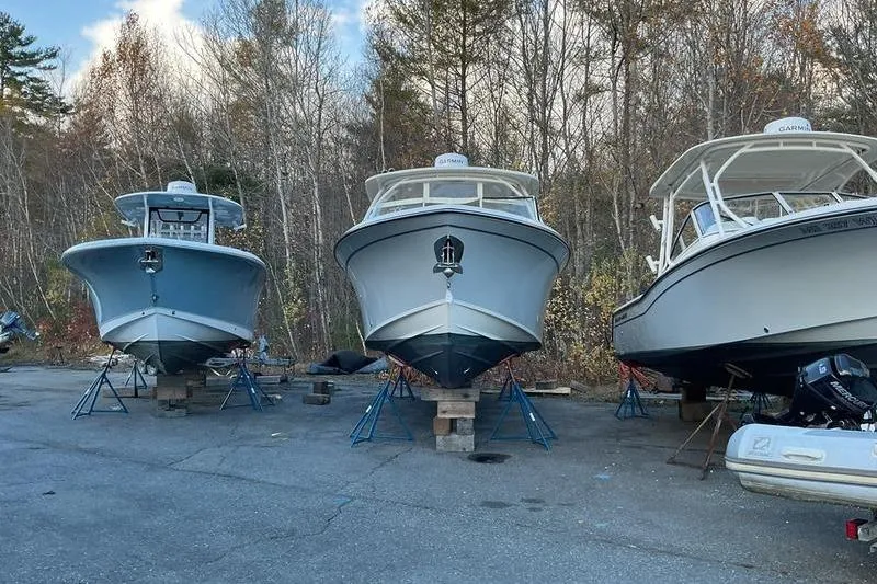 Slide: The Image of Three Grady-White Freedom 285 boats on stands in a wooded area, 2025 model. - 5