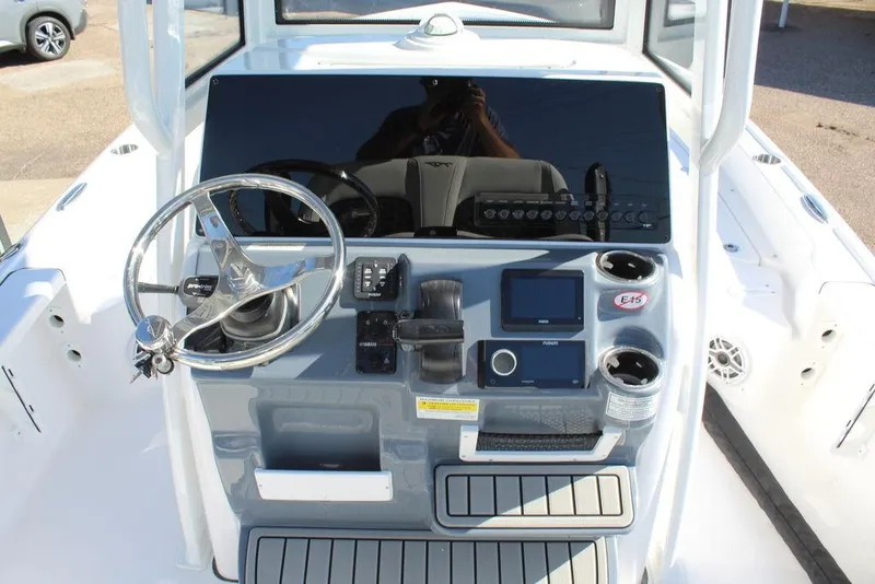 Slide: The Image of 2025 Tidewater 2210 Carolina Bay boat console with steering wheel and navigation controls. - 12
