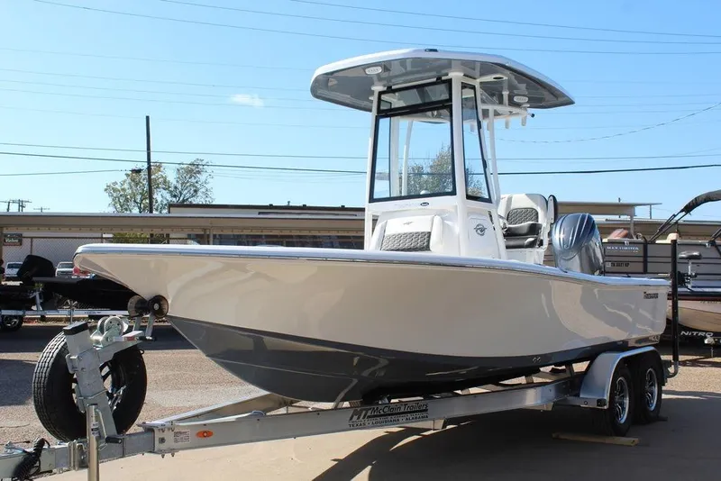 Slide: The Image of 2025 Tidewater 2210 Carolina Bay boat on trailer, sleek design, sunny day. - 13