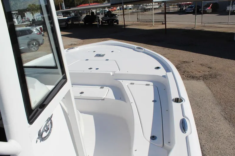 Slide: The Image of 2025 Tidewater 2210 Carolina Bay boat, sleek white deck, parked outdoors. - 15