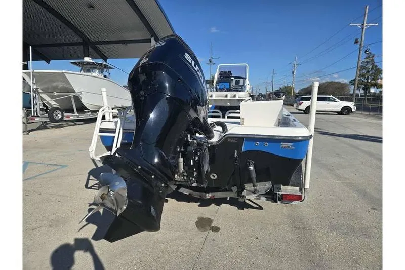 Slide: The Image of 2020 Blue Wave 2400 PureBay boat with powerful outboard motor in a marina setting. - 6