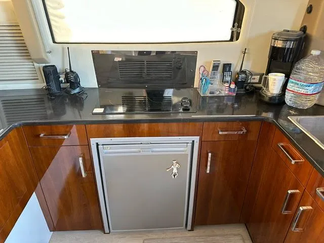 Slide: The Image of Interior of 2016 Carver C34 Command Bridge with kitchenette and modern appliances. - 12