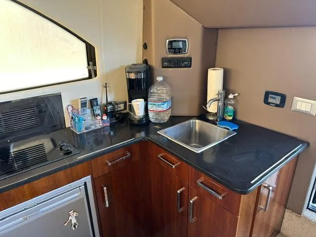 Slide: The Image of 2016 Carver C34 Command Bridge kitchen with sink, appliances, and storage cabinets. - 13