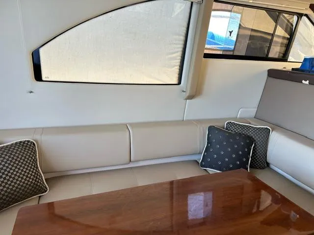 Slide: The Image of Interior of 2016 Carver C34 Command Bridge with beige seating and wooden table. - 14