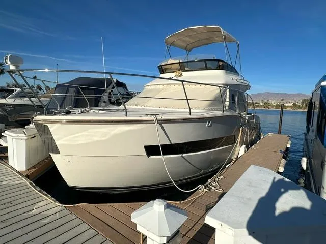 Slide: The Image of 2016 Carver C34 Command Bridge yacht docked at marina under clear blue sky. - 2