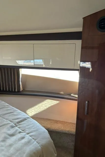 Slide: The Image of Interior of 2016 Carver C34 Command Bridge yacht, featuring sleek cabinetry and cozy bedding. - 21