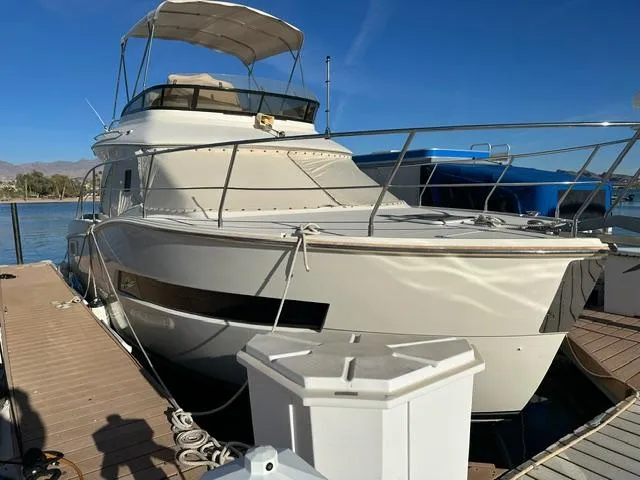 Slide: The Image of 2016 Carver C34 Command Bridge yacht docked at marina under clear blue sky. - 4
